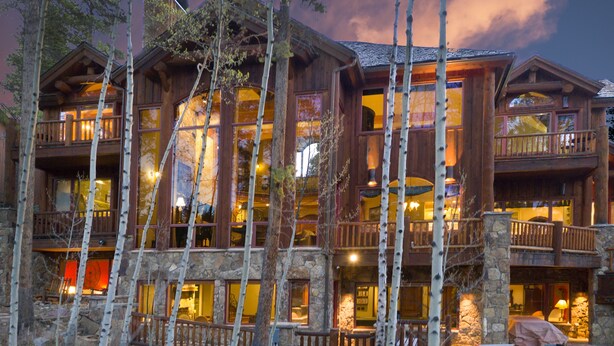 A multi-story lodge with balconies, large windows, and a stone facade.