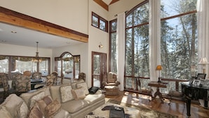 A spacious living room with a large window, a fireplace, and a cozy seating area.