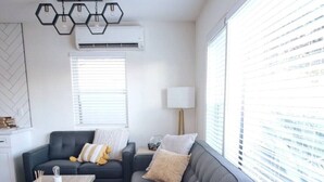 Una sala moderna con un sofá gris, una mesa de centro de madera y una planta en maceta.