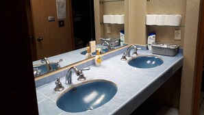 Une salle de bain avec deux lavabos, un miroir et un porte-serviettes.