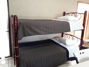 Una cama litera con dos niveles, cada uno con almohada y manta.
