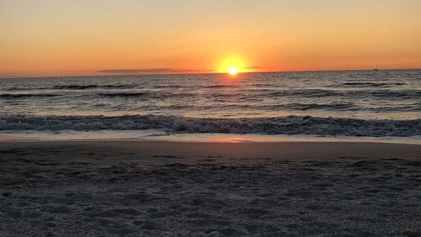 A beach at sunset with waves and a clear sky. - Beach / Pool Oasis in Beautiful Naples, Fl. (Naples)