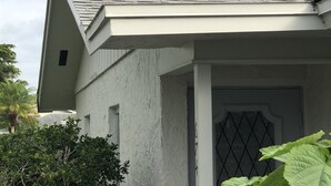 A white building with a sloped roof and a window with a diamond pattern. - Beach / Pool Oasis in Beautiful Naples, Fl. (Naples)