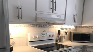A kitchen with white cabinets, a built-in oven, a microwave, and a gas stove. - Beach / Pool Oasis in Beautiful Naples, Fl. (Naples)
