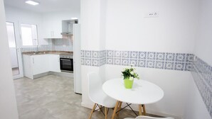 Una cocina moderna con armarios blancos, horno integrado y un salpicadero con diseño.