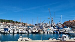 A marina with numerous boats docked, a crane, and buildings in the background. - House with view of the sea and vineyards; Near coastal path and town center (Port-Vendres)