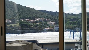 A coastal town with buildings on a hillside, a harbor with boats, and a clear sky. - House with view of the sea and vineyards; Near coastal path and town center (Port-Vendres)