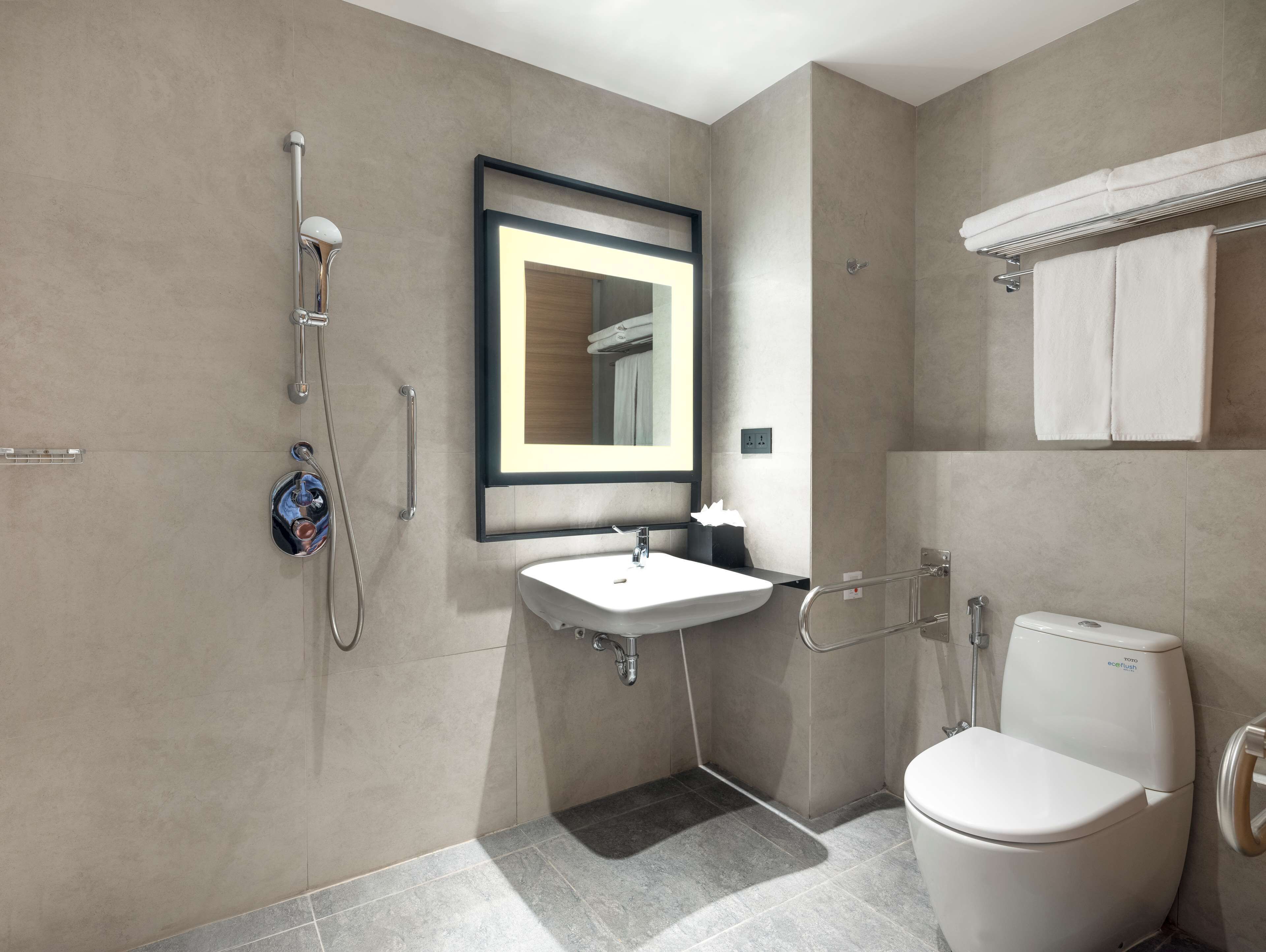 A modern bathroom with a toilet, sink, and shower.