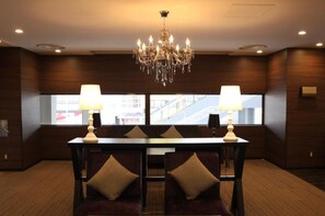Enjoy a spacious room with a large window offering a view of the outside, a chandelier, and a dining table with two chairs.