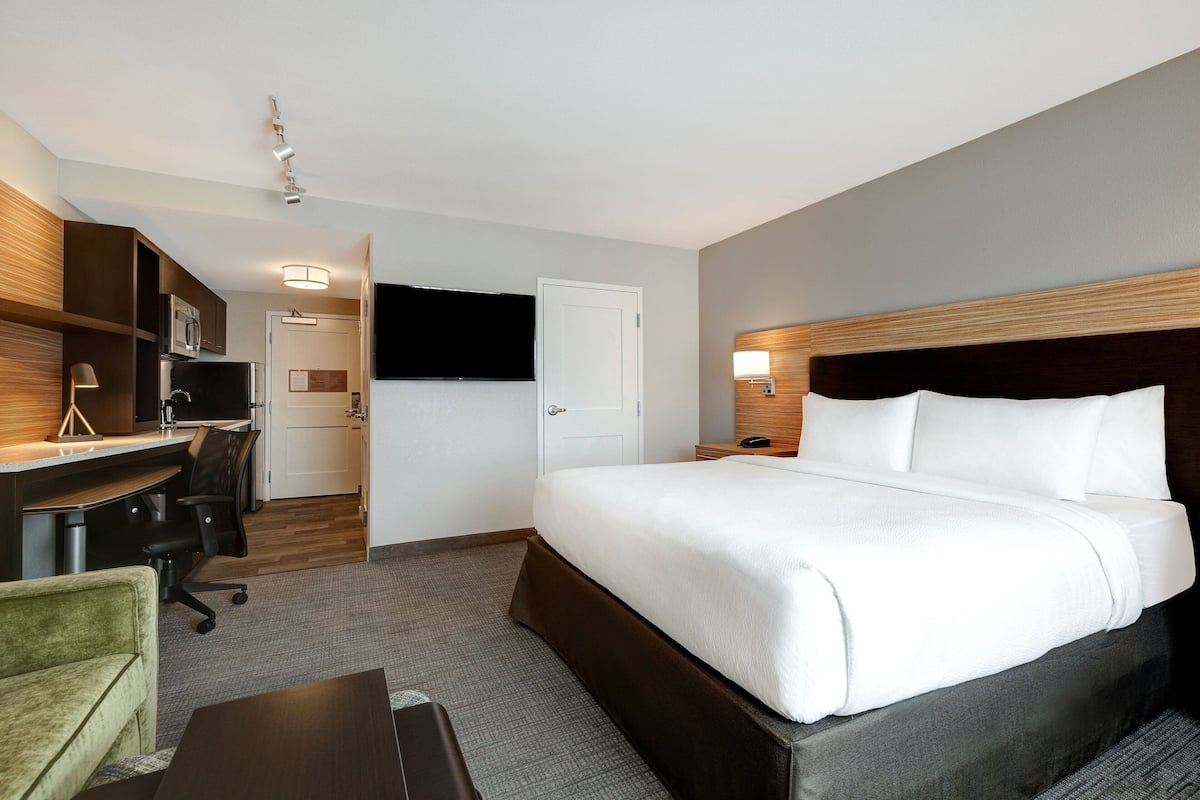 Une chambre d’hôtel équipée d’un lit, d’un bureau, d’une chaise et d’un téléviseur.