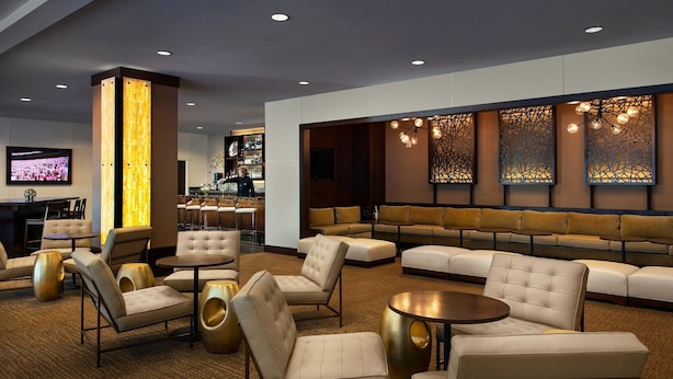 Un área de lounge moderna con sofás, sillones y una barra.