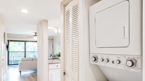 Une buanderie équipée d’un lave-linge, d’un sèche-linge et d’un système de ventilation.