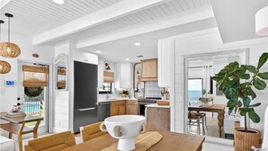 A modern kitchen with white cabinetry, a large island, and a view of the ocean. - Casa al Mare – Premier "True Beachfront" Living in Vero Beach!  Steps to sand! (Vero Beach)