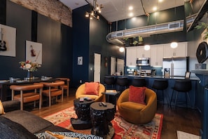 A modern living room with a dining area, kitchen, and bar.
