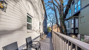 A wooden deck with outdoor furniture, a railing, and a building with a window and a door. - Honky Tonk Hideaway on Music Row (Nashville)
