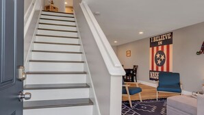 A staircase leading to a dining area with a wall sign that reads "I BELIEVE IN NASHVILLE." - Honky Tonk Hideaway on Music Row (Nashville)