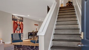 Una escalera con escalones de madera y una puerta oscura.