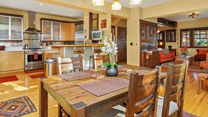 A spacious kitchen with modern appliances, a dining area with wooden furniture, and a cozy living room with a fireplace.