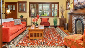 A cozy living room with a red sofa, a wooden coffee table, and a patterned rug.