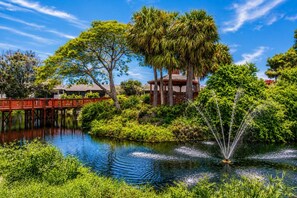 A serene garden with a pond, a wooden bridge, and a gazebo. - Park Shore Resort 1st Floor condo, BLDG I #152 (Park Shore Resort)