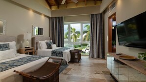 A hotel room with two beds, a TV, and a balcony with a view of palm trees.
