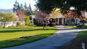 A residential driveway leading to a house with a mailbox and a street sign. - Dominion Brook Park Vacation Rental - Beautiful suite with garden / park views. (North Saanich)