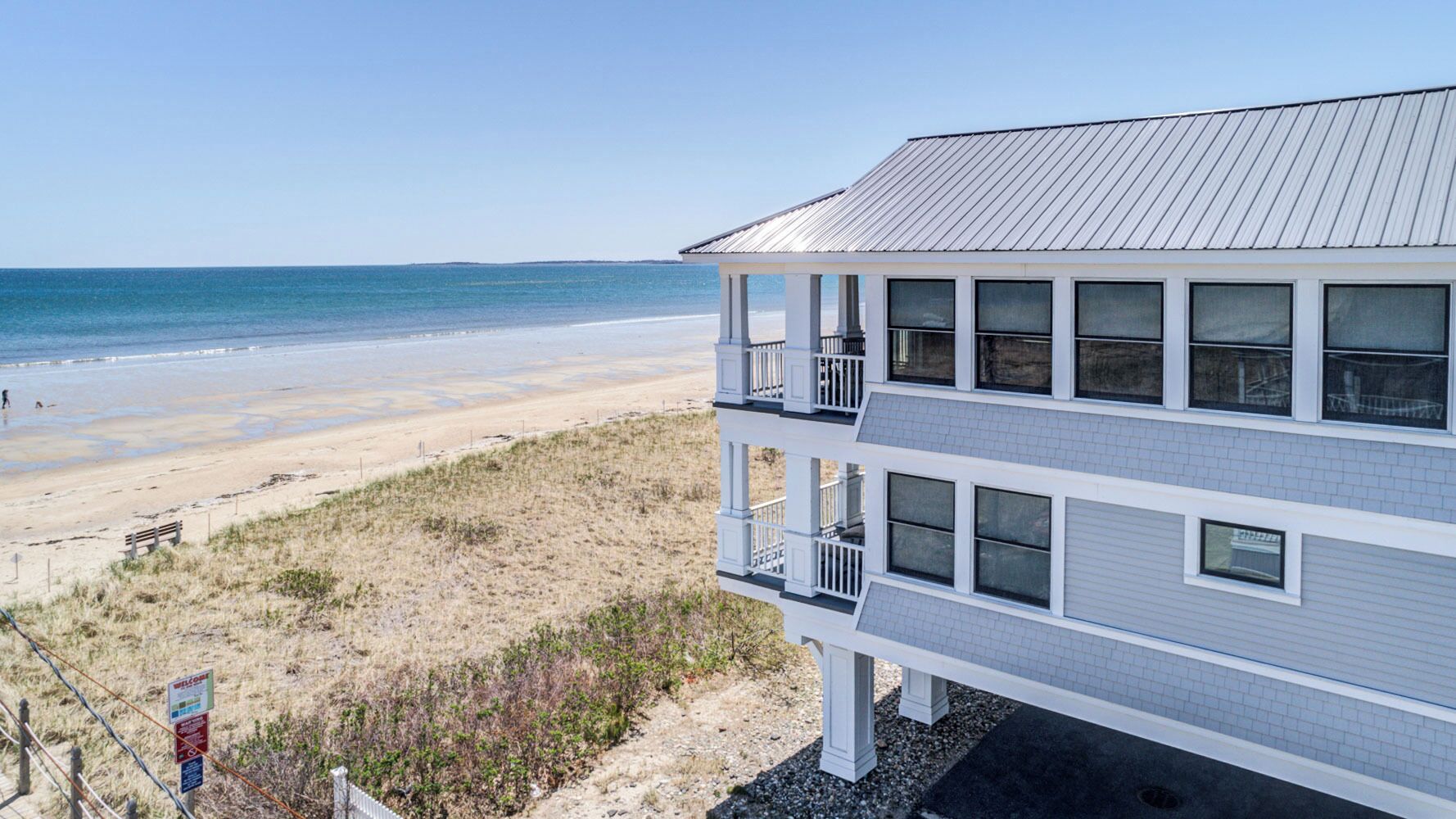 Un edificio frente a la playa con varios balcones que dan al océano.
