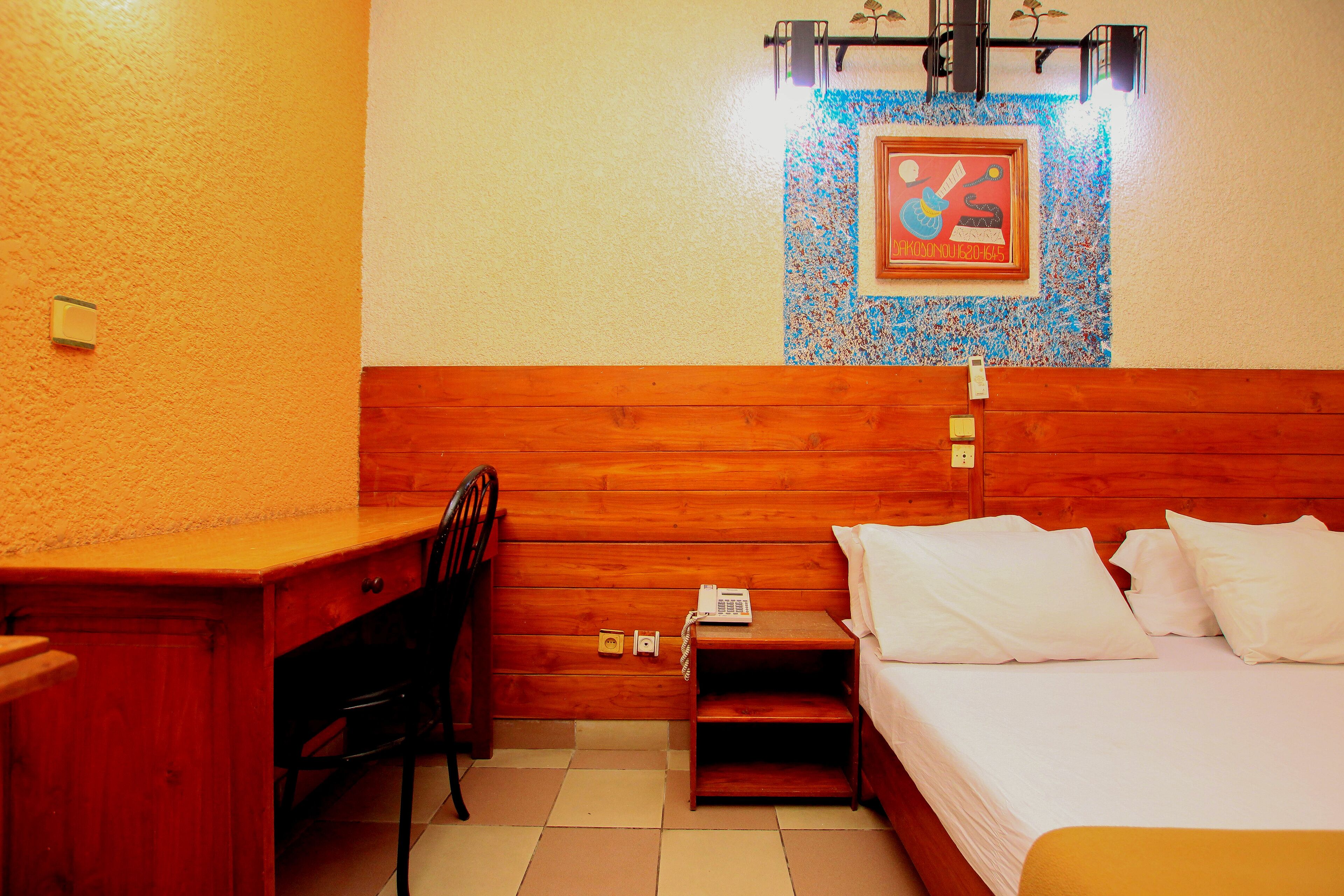 A wooden-framed room with a bed, a desk, and a chair.