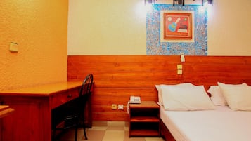 A wooden-framed room with a bed, a desk, and a chair.