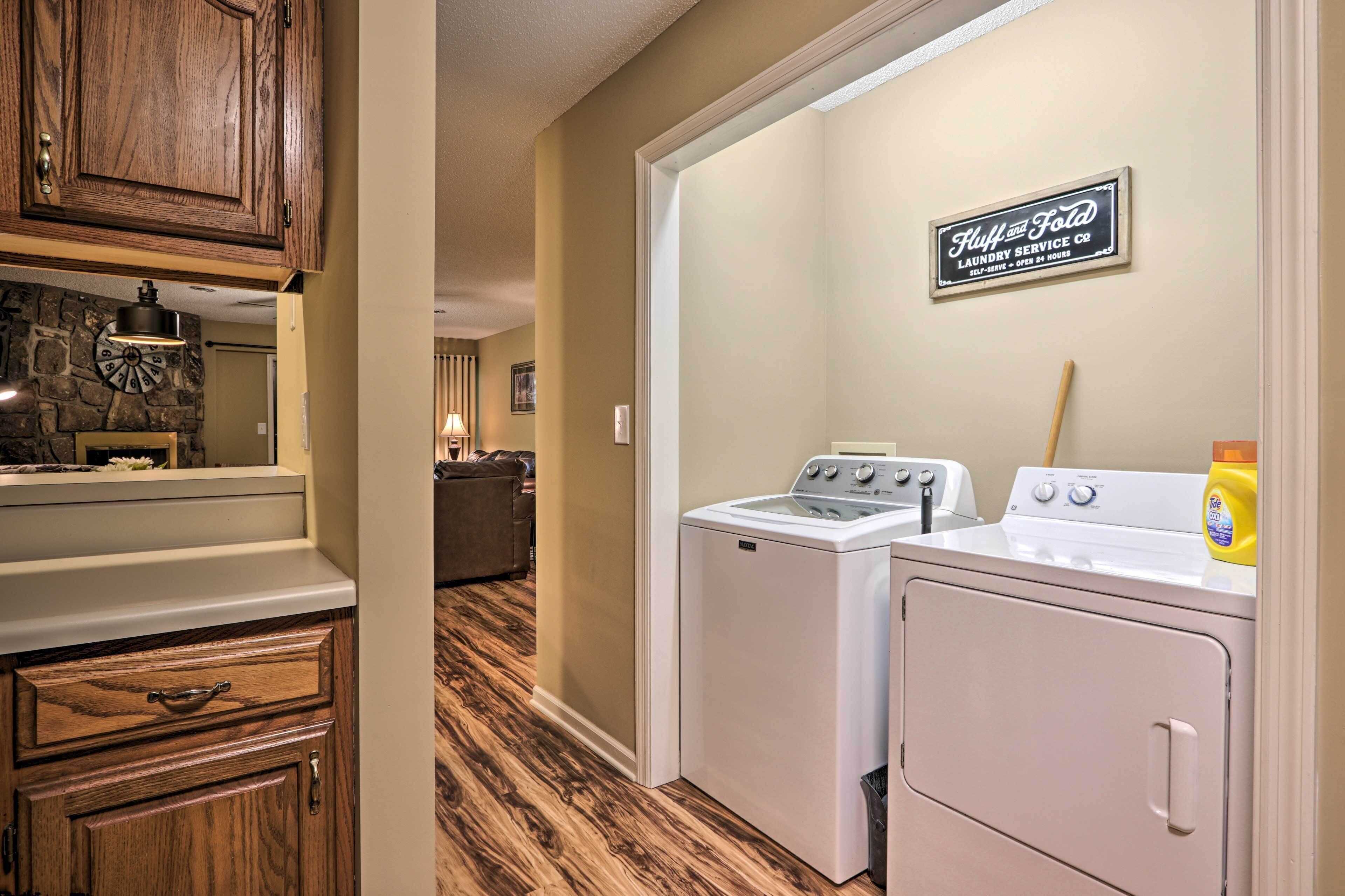 A laundry room with a washing machine, dryer, and a sign for 'Huff and Fota Laundry Service Co.'