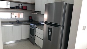 Eine moderne Küche mit Edelstahlgeräten, einem Gasherd, einem Backofen und einem Kühlschrank.