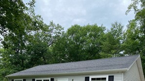 A single-story house with a number 9285 on the door, surrounded by a well-maintained lawn and gravel driveway.