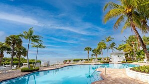 Una piscina con palmeras y vista al océano.