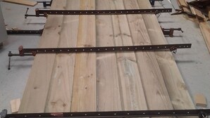 A workshop with wooden planks and metal straps, tools, and a tire on the floor. - kopuha Small Batch 
Not available at the moment (Tekapo)