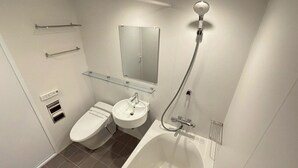 Et moderne badeværelse med toilet, håndvask og badekar.