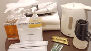 A variety of toiletries including shampoo, conditioner, body soap, and a body sponge. - Hotel Shion no umi (Miyakojima)