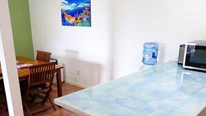 A kitchen with a marble countertop, a water dispenser, and a microwave. - Hidden by beautiful palm and flamboyant trees but close to restaurants & stores  (Christiansted)