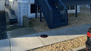A two-story house with a covered porch and a staircase leading to the second floor. - Luxury beach house   (Seaside Heights)