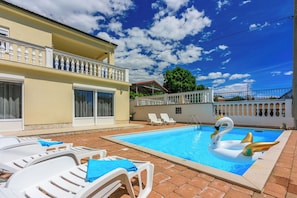 A swimming pool with lounge chairs and a swan float.