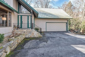 A house with a garage, stone steps, and a metal roof.