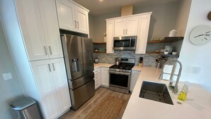 A modern kitchen with stainless steel appliances, white cabinetry, and a clean layout. - *Cali King Bed * Bright Natural Light * Tall Ceilings * Full Kitchen * Balcony (San Diego)