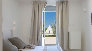 Ein Hotelzimmer mit einem Bett, zwei Kissen, einer Decke und Blick auf ein Gebäude.