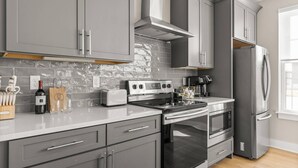 A modern kitchen with grey cabinetry, a stainless steel range, a built-in oven, and a refrigerator. - Duke9 ~ Private Penthouse Rooftop ~ Newly Redesigned Interior ~ 8 Min to Downtown and Broadway (Nashville)