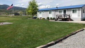 Un bâtiment d’un seul étage, doté d’un toit bleu, d’un mât sur lequel flotte le drapeau américain, et d’une petite terrasse avec un banc.