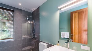 Moderni kylpyhuone, jossa on suihku, wc ja pesuallas.
