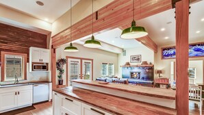 Eine moderne Küche mit Holzbalken, weißen Schränken und einer zentralen Kochinsel.