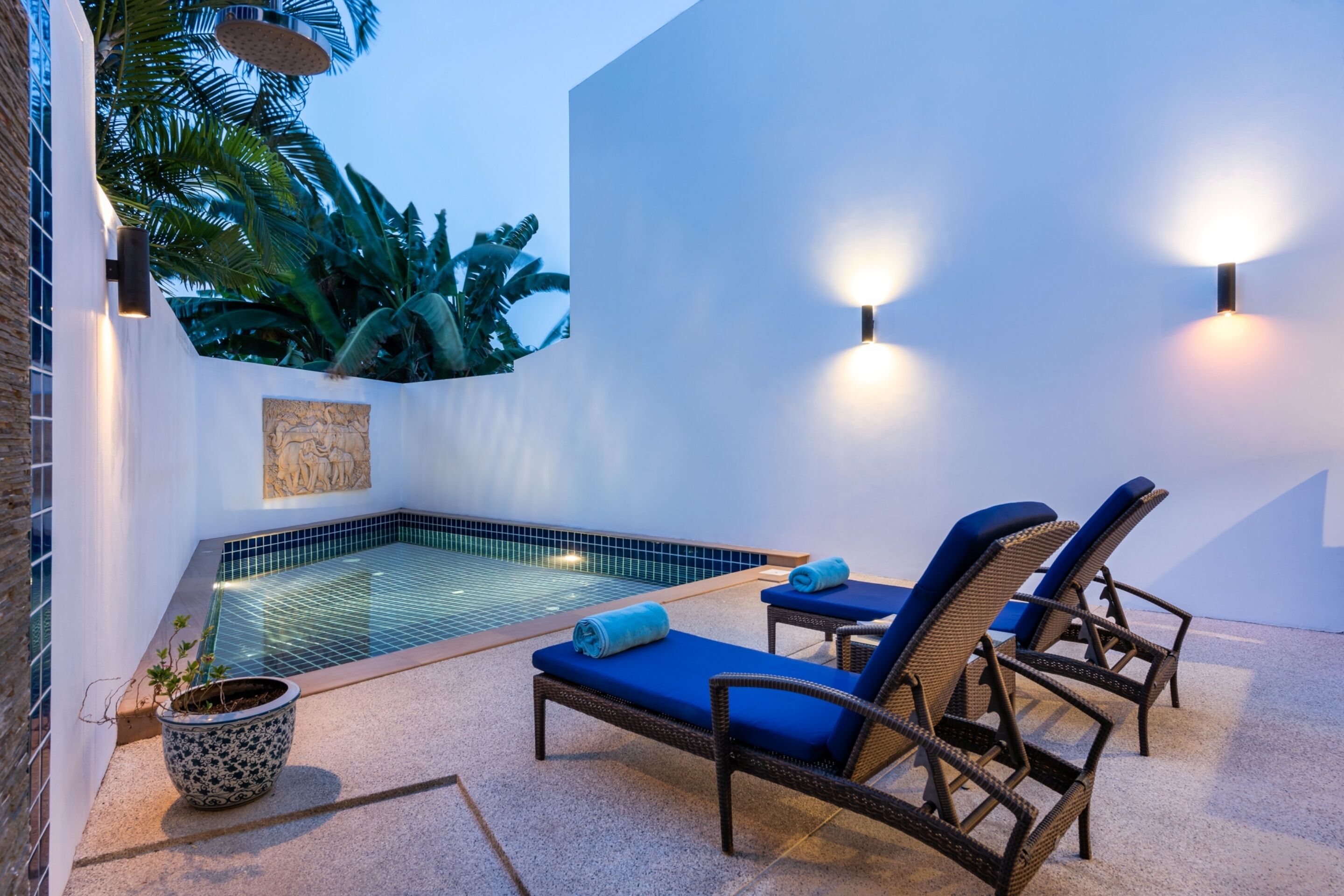 Uma área de piscina com espreguiçadeiras e uma pequena banheira de hidromassagem.
