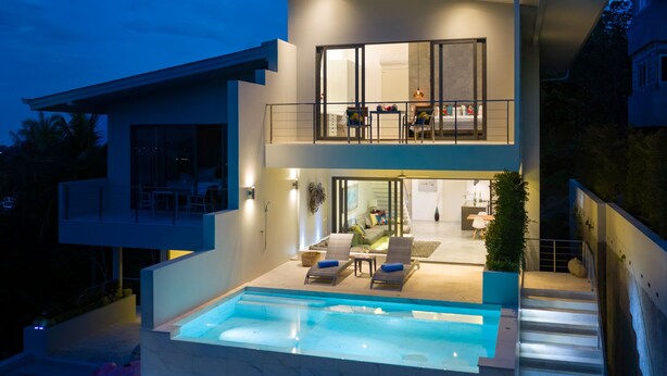 A modern two-story house with a swimming pool, outdoor seating, and a balcony. - Villa Palm Vista - Luxury, Private Pool Villa (Koh Samui)