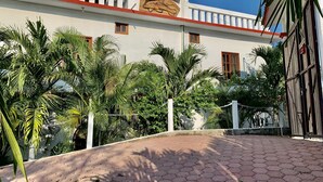 A white building with a sign reading "Casa El Dorado," surrounded by lush greenery and a paved walkway. - Casa El Delfin, 2nd Floor-Apt. 1 -  Estacahuite (Estacahuite)