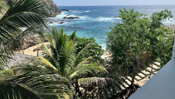 A coastal view with a beach, palm trees, and rocky cliffs. - Casa El Delfin, 2nd Floor-Apt. 1 -  Estacahuite (Estacahuite)